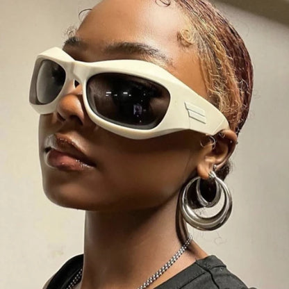 Person wearing futuristic sunglasses with a neutral background
